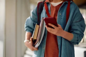 aluno no celular tirando dúvidas assessoria acadêmica